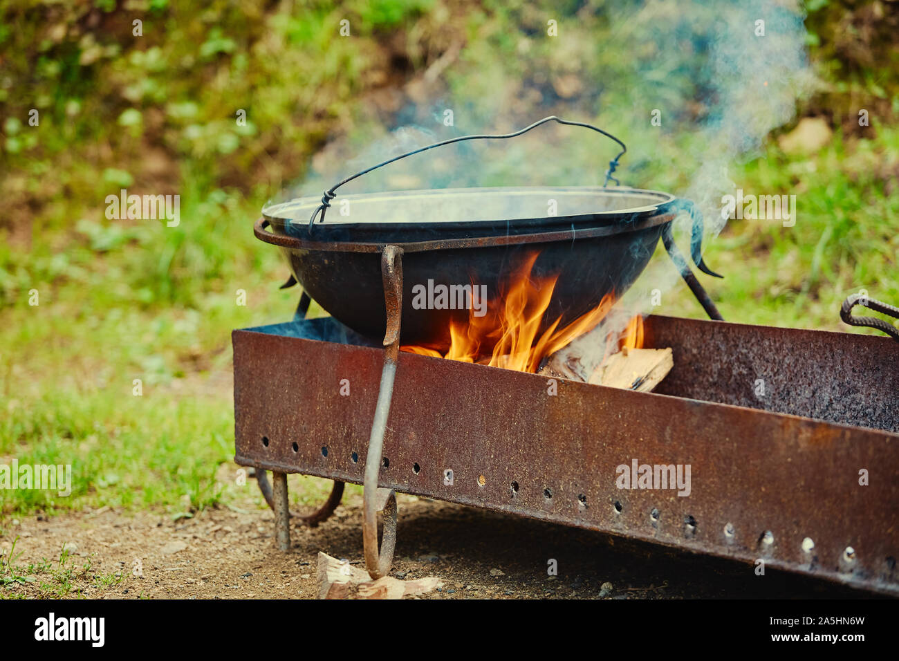Une chaudière de métal se dresse sur un grill au feu de bois, dans le  tourisme ou de stationnement Photo Stock - Alamy