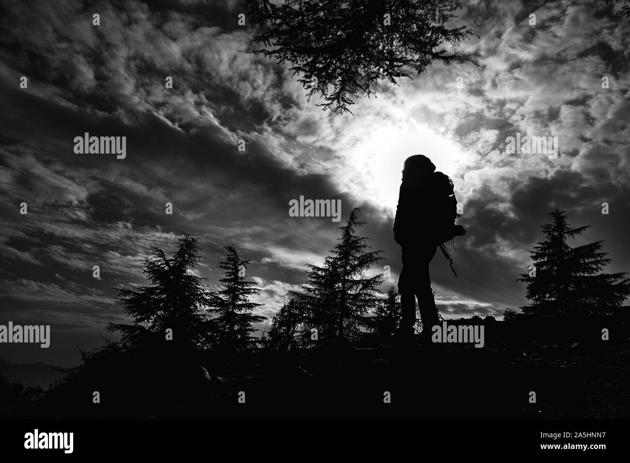 Voyage en noir et blanc silhouette d'un homme trekking jusqu'à la colline Banque D'Images