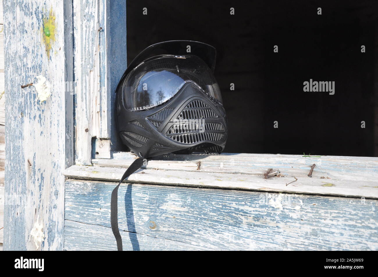 L'équipement de Paintball. Casque de sécurité complet avec masque de visage, prêt à porter dans la bataille. Dans la fenêtre de la chambre. Banque D'Images