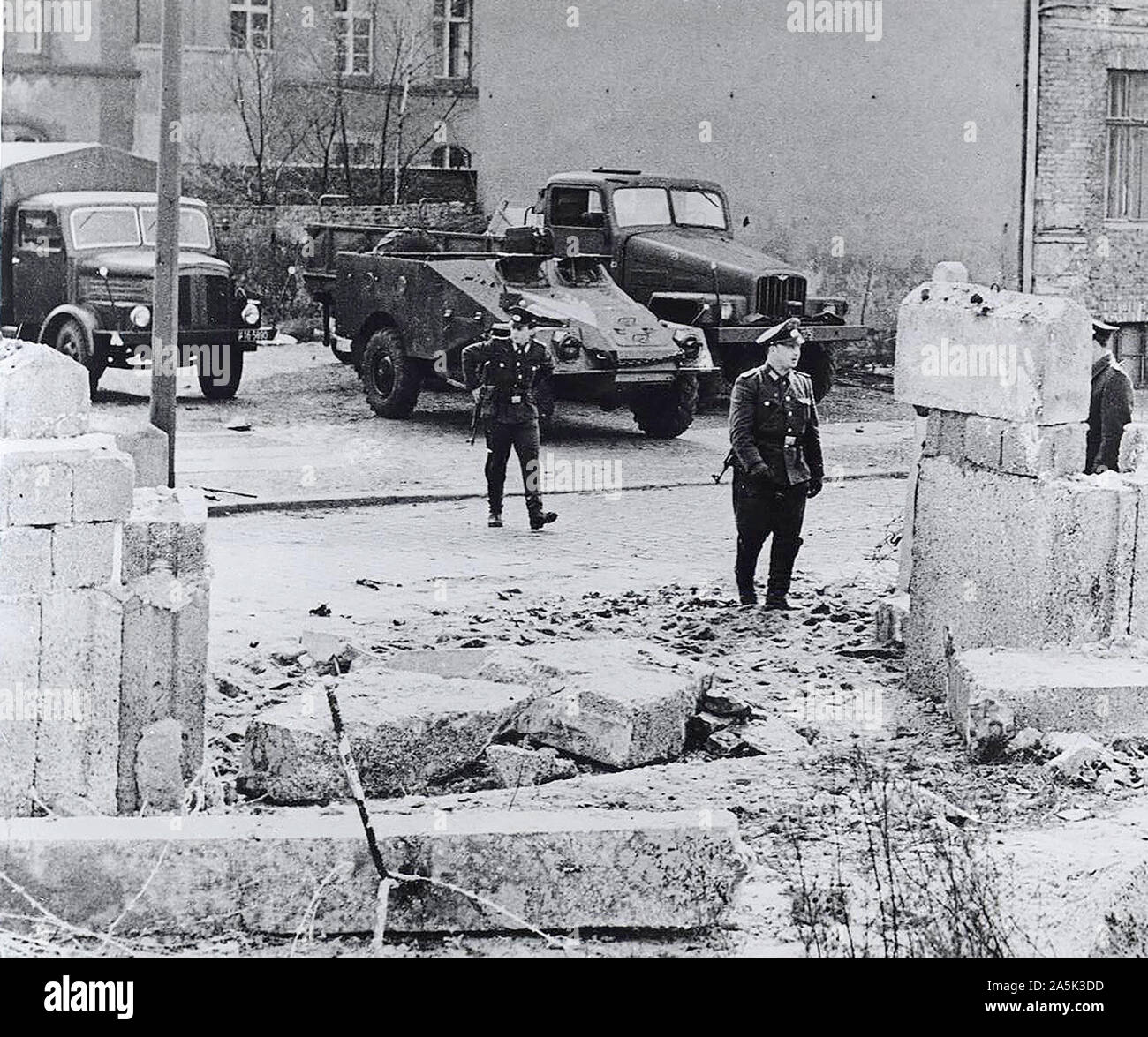 Les réfugiés a enfoncé le mur avec un camion lourd et s'est ensuite enfui à pied dans le secteur français de Berlin Ouest lorsque leur camion au point mort dans les décombres. Les gardes allemandes est tiré plusieurs coups de feu sur eux mais manqué. Dans l'arrière-plan sont les véhicules militaire communiste posté après l'incident, afin de prévenir d'autres évasions. Banque D'Images