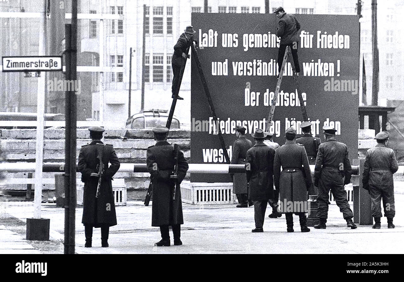 12/8/1961 - Friedrichstrasse. 'Comprendre' est en minuscules dans la zone soviétique Régime. à la frontière de Vopos il a déclenché un débat, et après un certain temps un Vopos gravit les échelons et faite avec de la peinture blanche de la petite V est un grand 'V' Banque D'Images