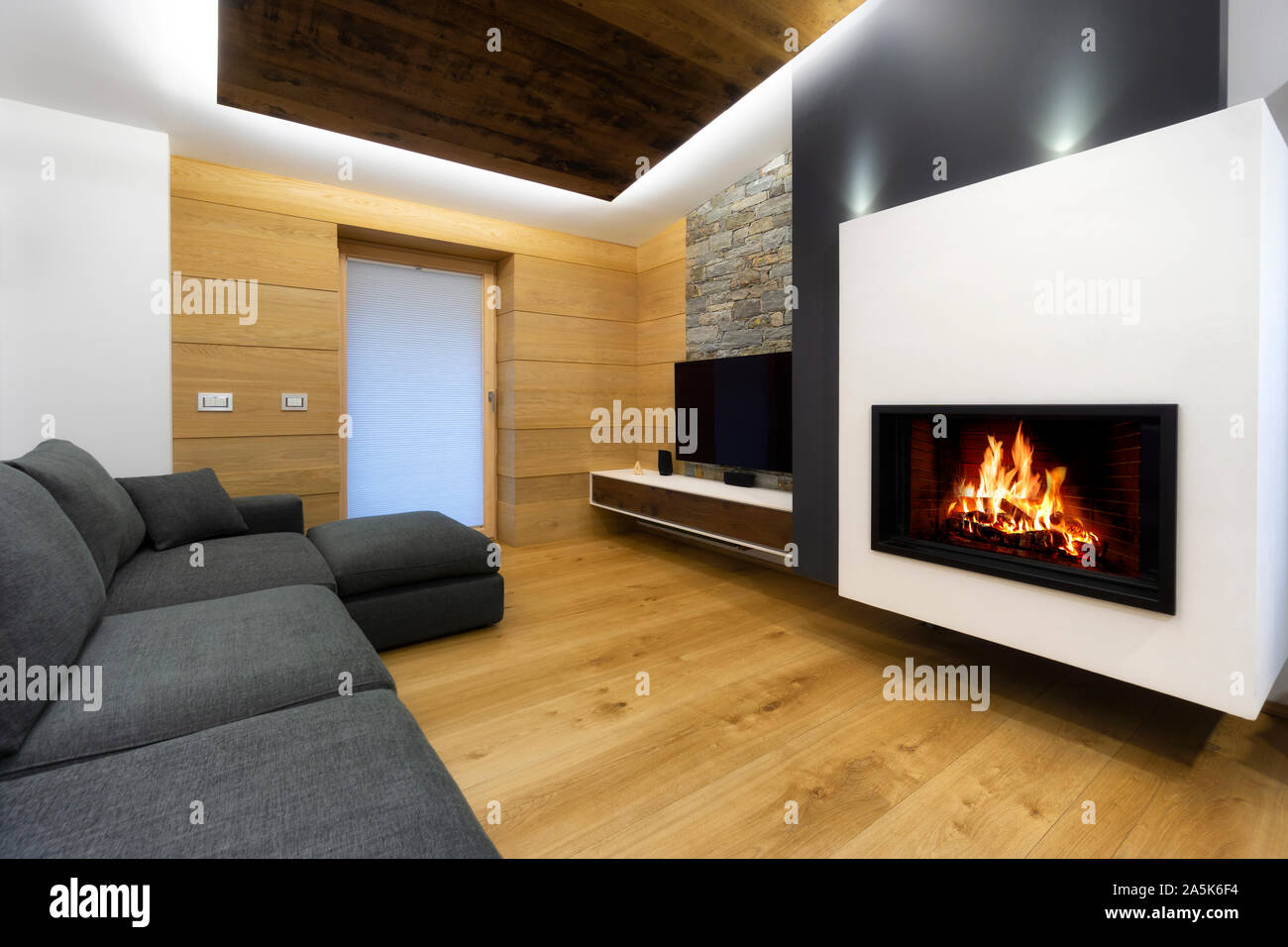Salon moderne en bois intérieur avec canapé et cheminée Banque D'Images