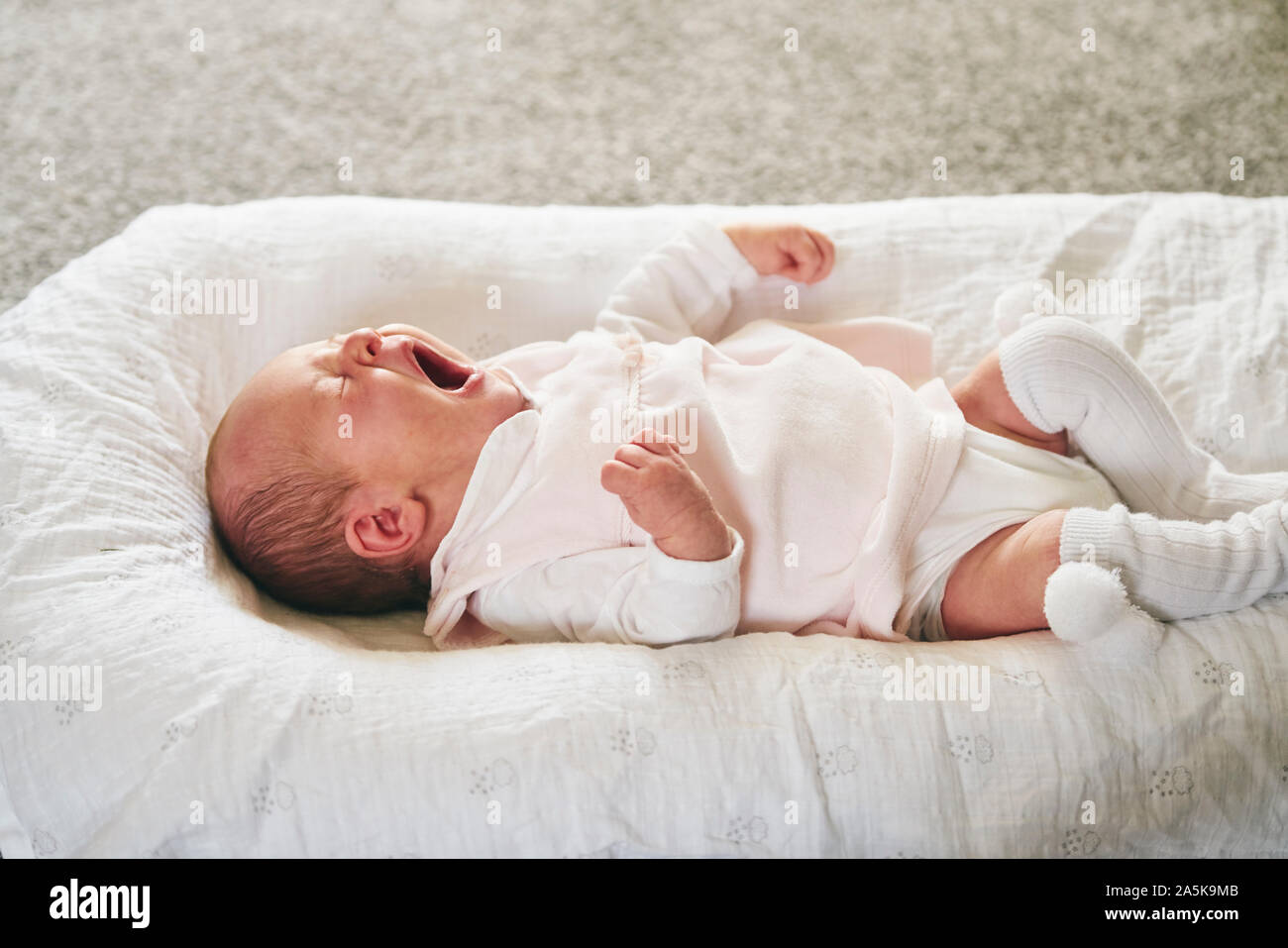 Bâillements bébé sur coussin en forme de U à la maison Photo Stock - Alamy