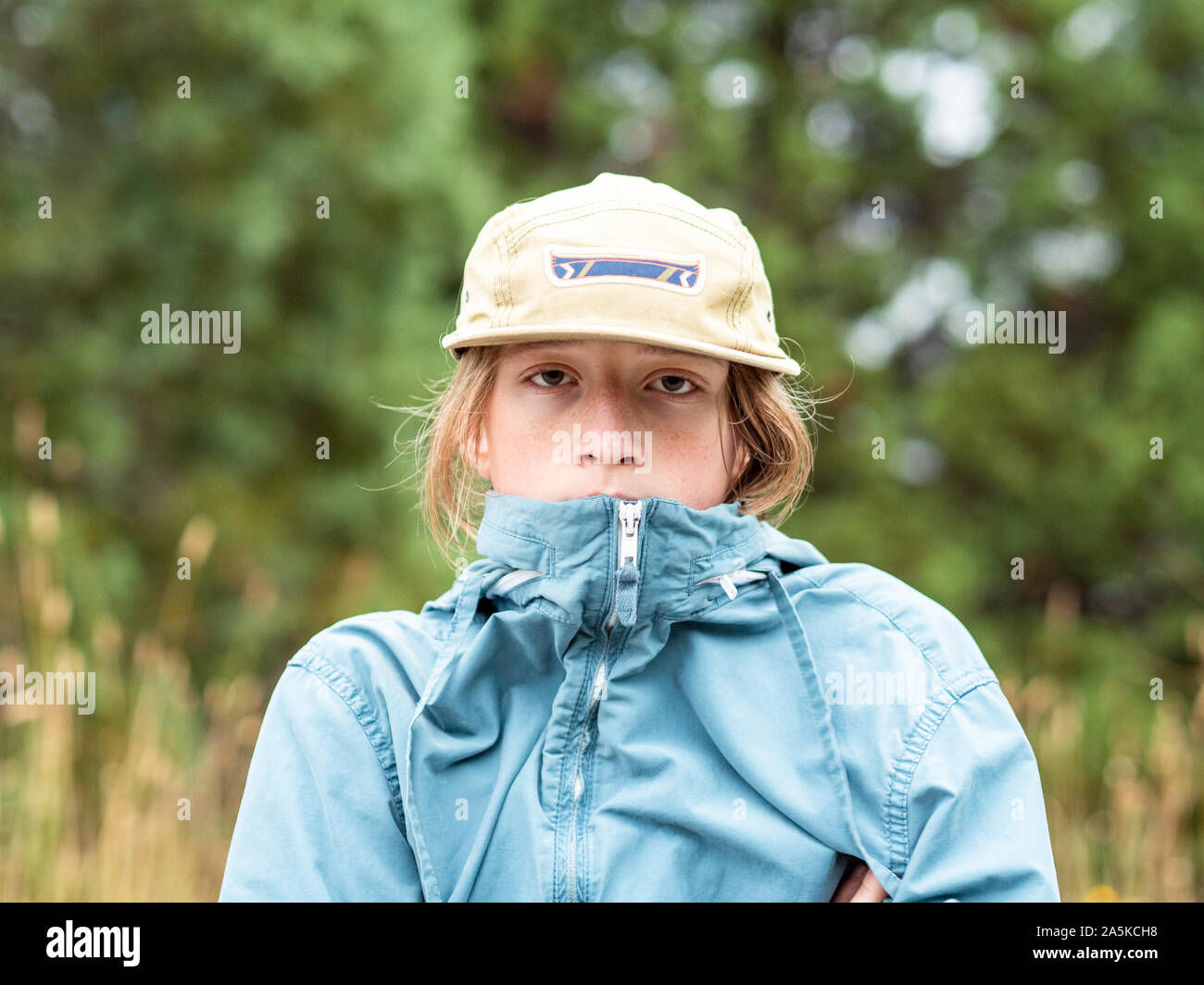 Portrait of teenage boy with wind breaker et hat outdoors Banque D'Images