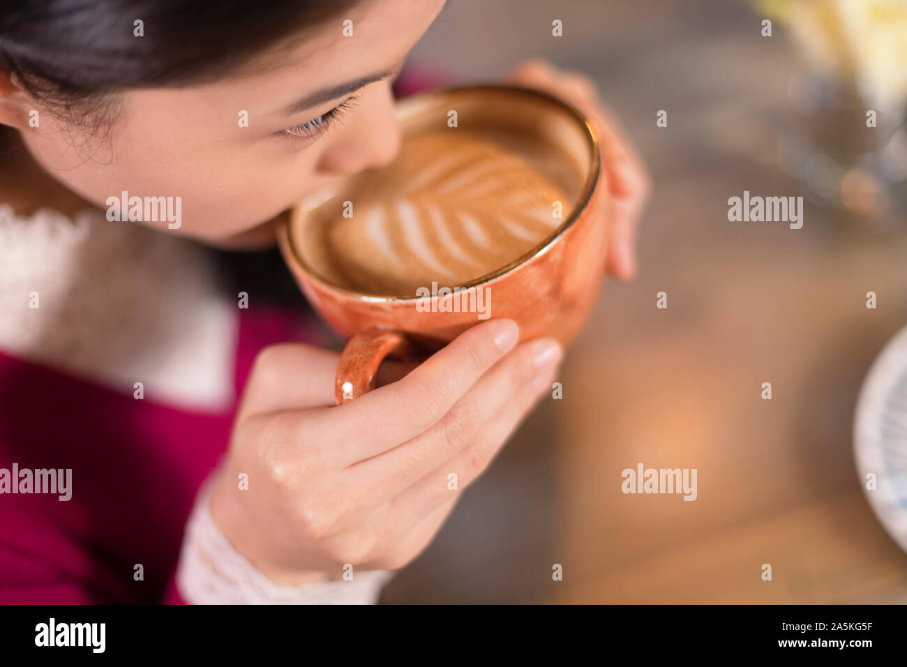 Woman drinking coffee in cafe Banque D'Images