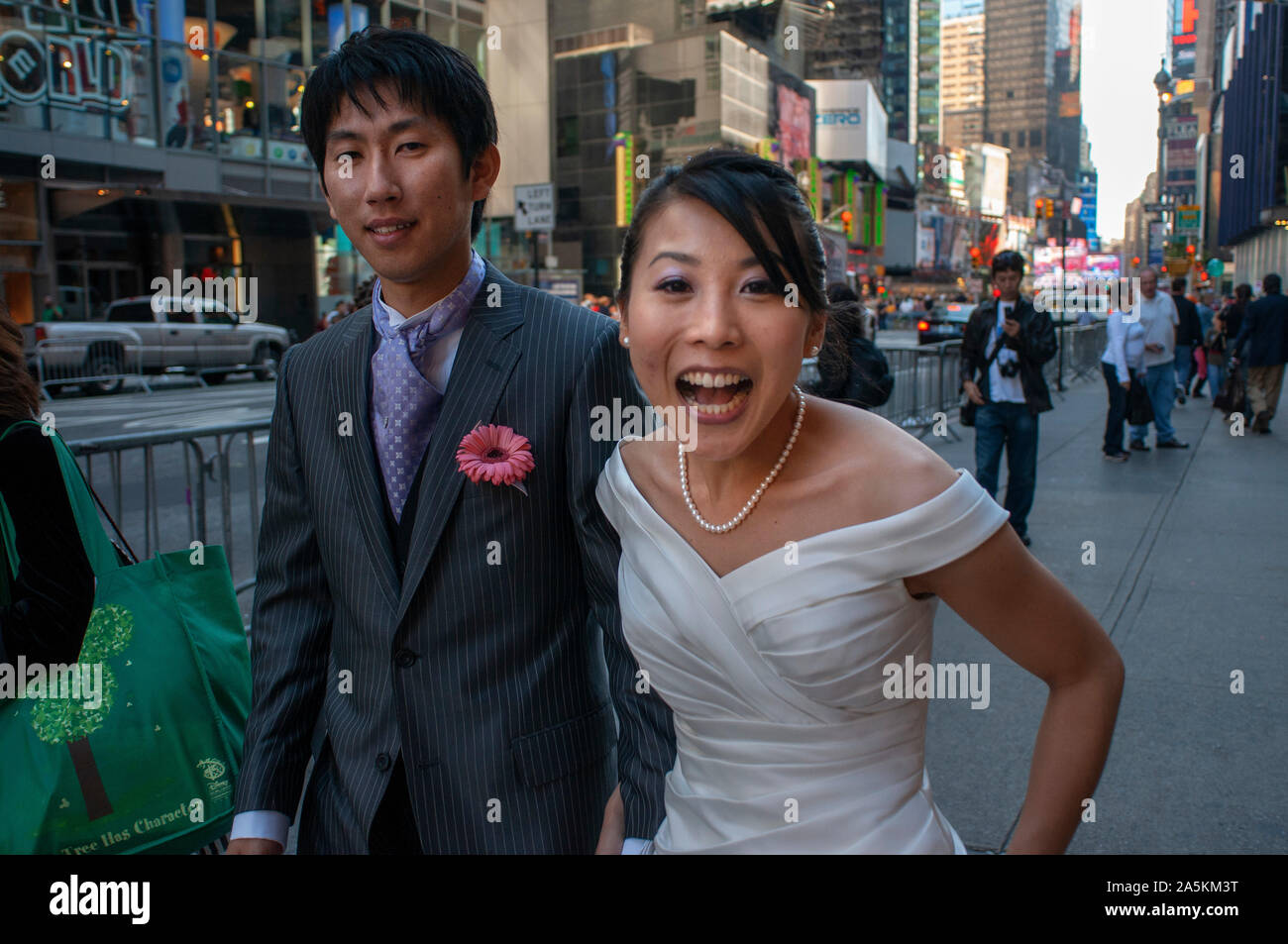 Couples nuptiales asiatiques sur un escalier posant pour une photo à Times Square, New York USA Banque D'Images