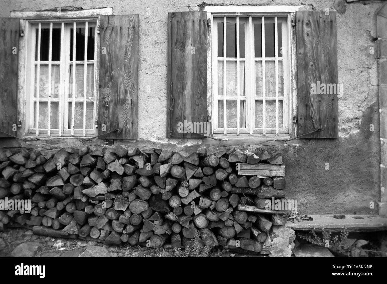 Mijanès, Ariège, Occitanie, France : gîte avec un tas de bois stockés prêt pour l'hiver. Version noir et blanc Banque D'Images