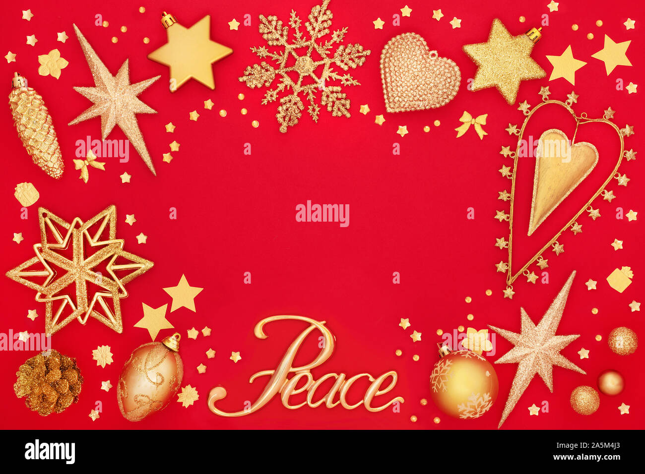 Bordure de l'arrière-plan de Noël avec de l'or signe de paix et de star et décorations babiole sur rouge. Carte de vœux traditionnels pour les fêtes. Banque D'Images