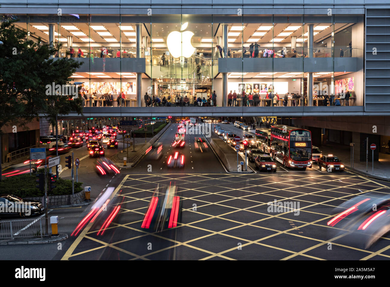 Le trafic passe sous l'Apple flagship store à l'IFC Mall on Lung Wo Road dans le quartier central de Hong Kong. Banque D'Images