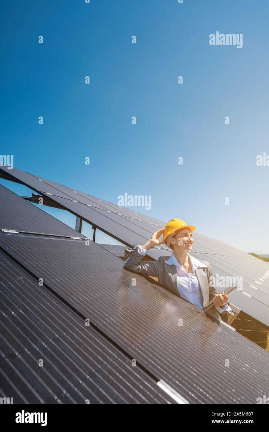 Femme d'affaires ou de l'investisseur l'inspection de sa ferme solaire Banque D'Images