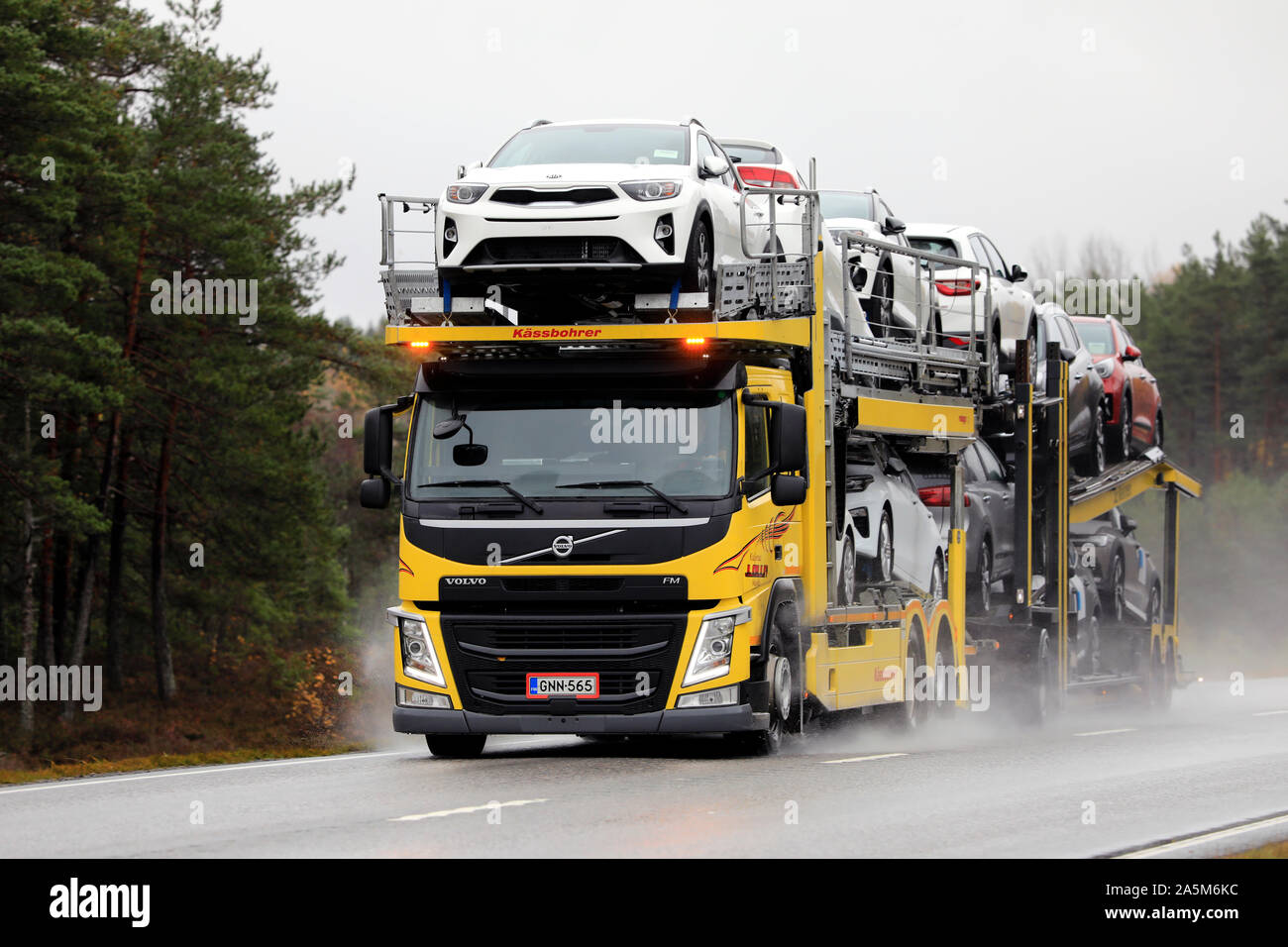 Volvo FM transporteur véhicule jaune de Kuljetus J. Olli Oy transporte une charge de nouvelles voitures sur route humide en automne. Tenhola, Finlande. 18 octobre, 2019. Banque D'Images