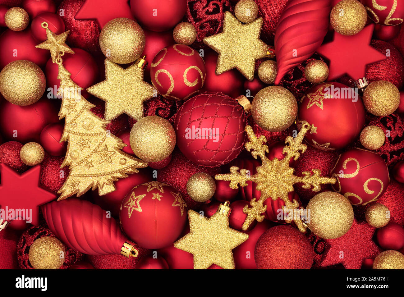 Arbre de Noël rouge et or décorations babiole formant un motif de fond. Symboles traditionnels pour les fêtes. Banque D'Images