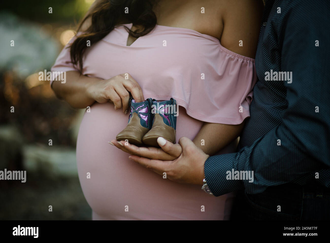 Couple holding baby boots en face de baby bump Banque D'Images