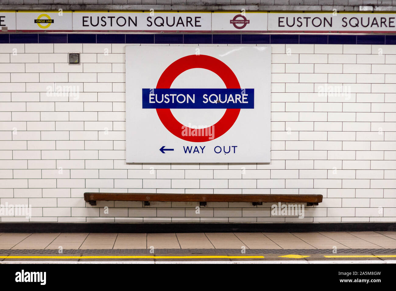 La station de métro Euston Square Londres avec un banc vide et une flèche dirigée vers la porte de sortie Banque D'Images