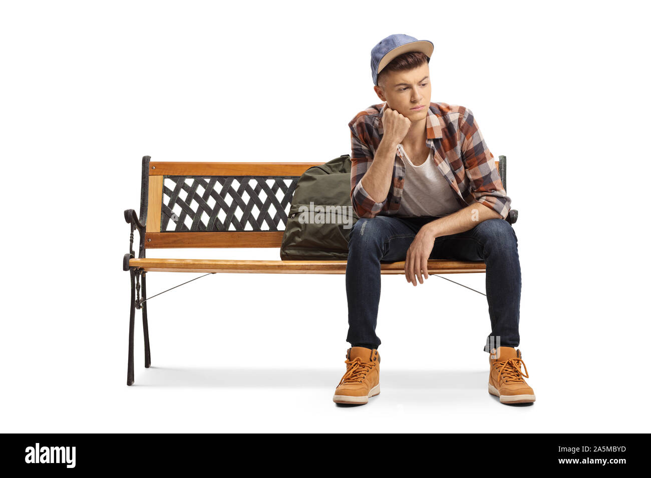 Inquiets young male student assis sur un banc et à l'écart isolé sur fond blanc Banque D'Images