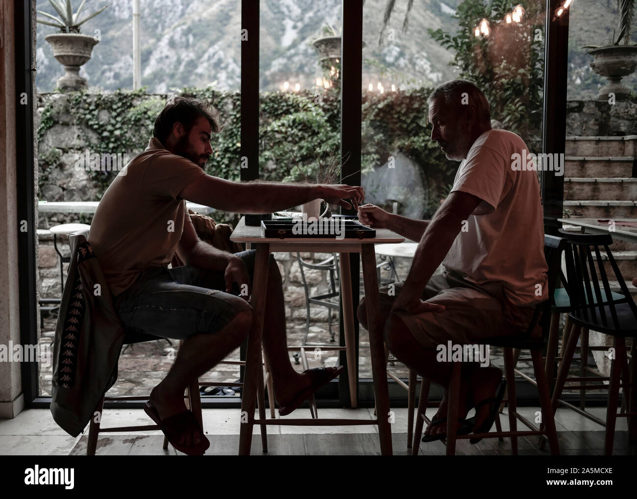 Dobrota, Monténégro, 19 sept., 2019 : Père et fils jouant au backgammon au café Banque D'Images