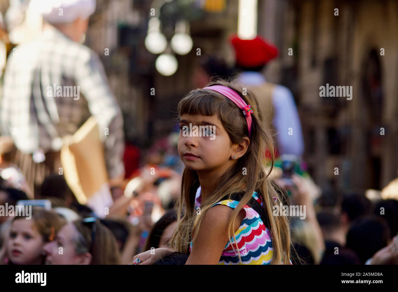 Une jeune fille regarder la parade de géants au cours de la Merce 2019 Festival à Plaça de Sant Jaume de Barcelone, Espagne Banque D'Images