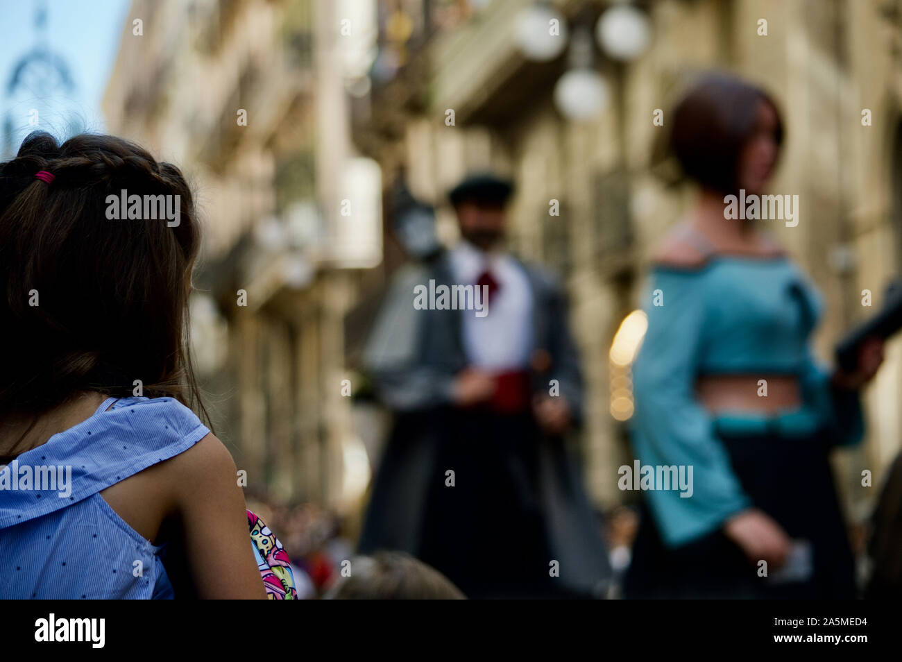 Une jeune fille regarder la parade de géants au cours de la Merce 2019 Festival à Plaça de Sant Jaume de Barcelone, Espagne Banque D'Images