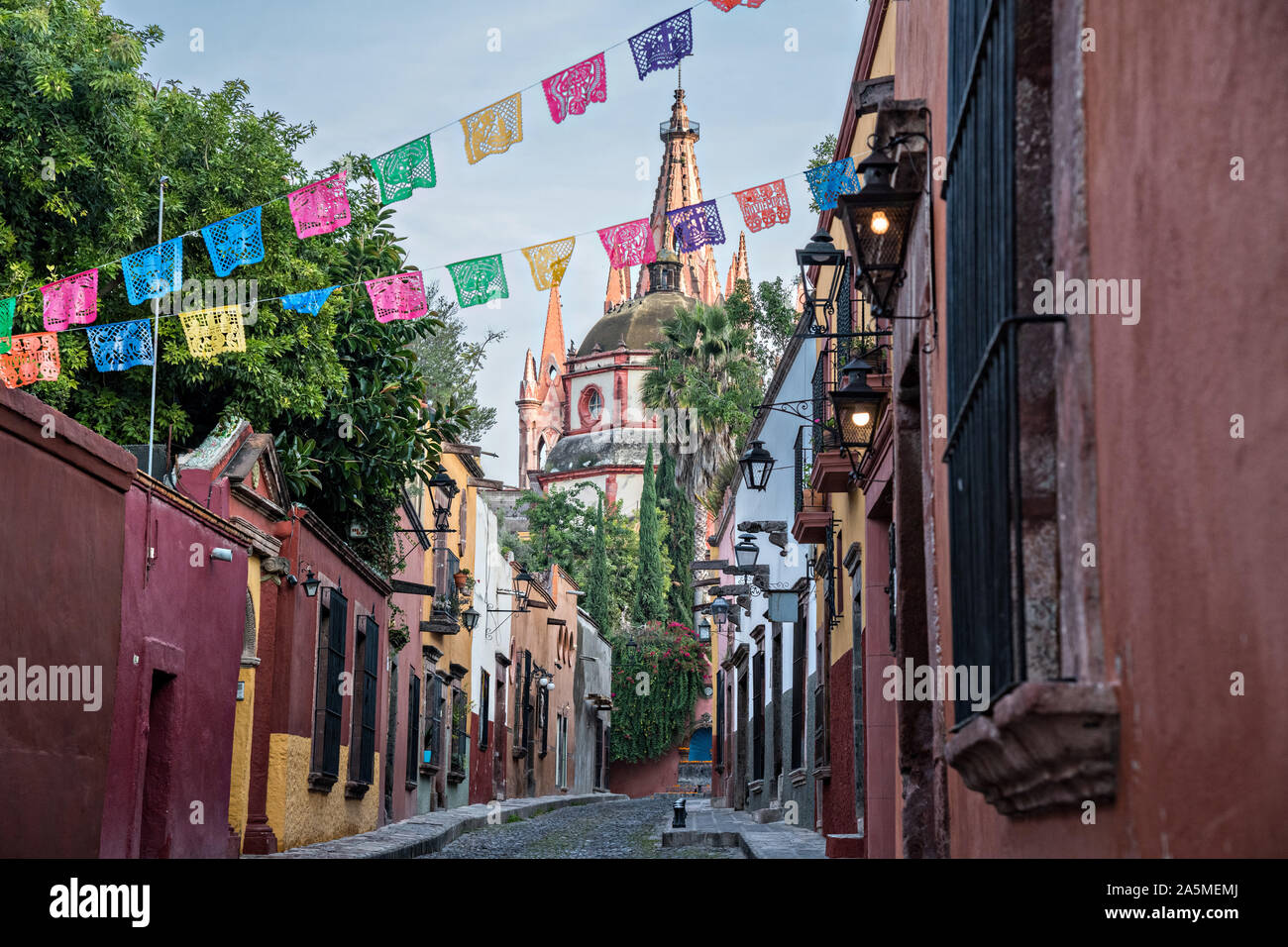 Les dômes et les clochers de la Parroquia San Miguel Arcangel church vu à travers des banderoles de papier appelé papel picado sur Aldama Street dans le quartier historique de San Miguel de Allende, Mexique. Banque D'Images