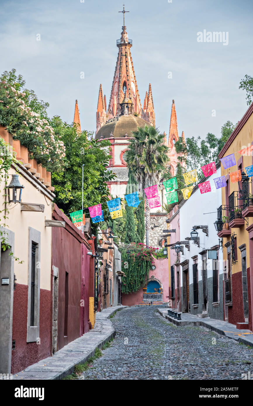 Les dômes et les clochers de la Parroquia San Miguel Arcangel church vu à travers des banderoles de papier appelé papel picado sur Aldama Street dans le quartier historique de San Miguel de Allende, Mexique. Banque D'Images