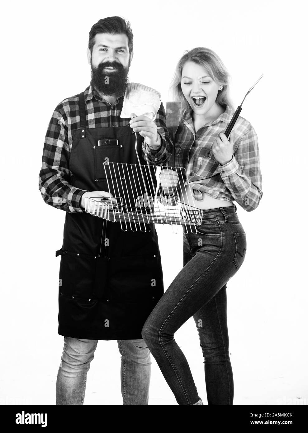 Joie de style de cuisine barbecue. Jolie femme et homme barbu tenant grille de cuisson. Couple heureux à l'aide de la grille de cuisson pour barbecue. Profitez de la cuisson des aliments sur le gril. Banque D'Images