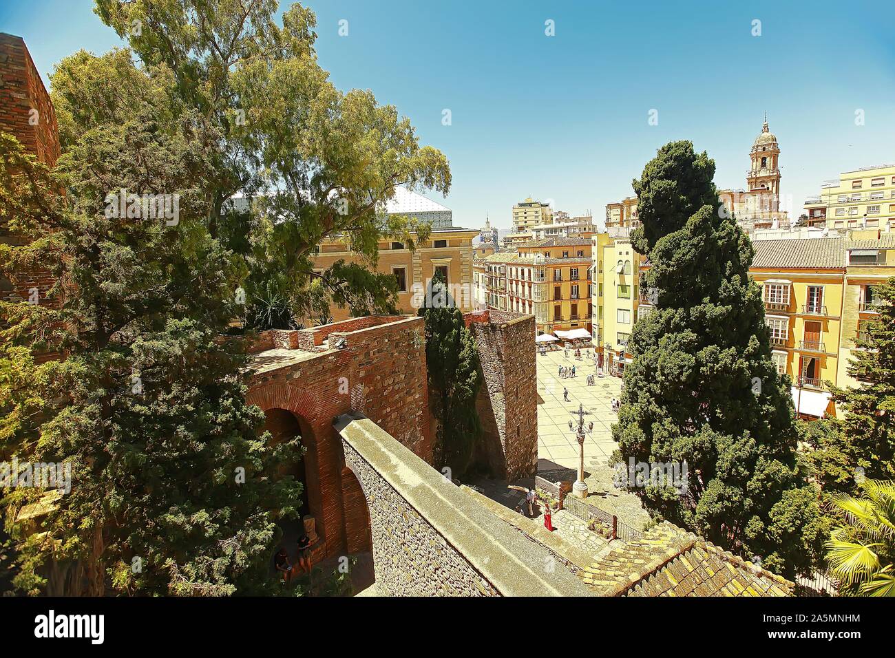 Photo en grand angle d'un coin de rue plein de bâtiments et d'arbres en Espagne, Malaga Banque D'Images