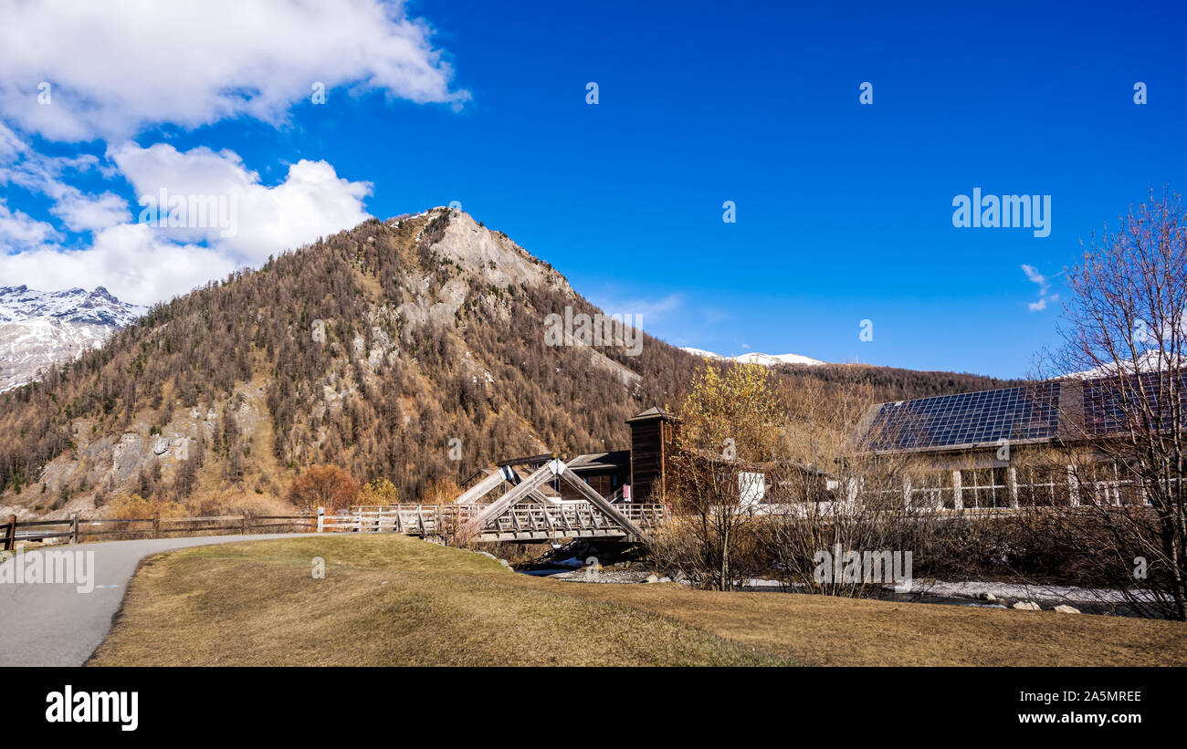 Belle vallée montagneuse avec ruisseau, arbres, sentier et pont de bois, Livigno est une petite ville et centre de ski des Alpes italiennes, Italie Banque D'Images