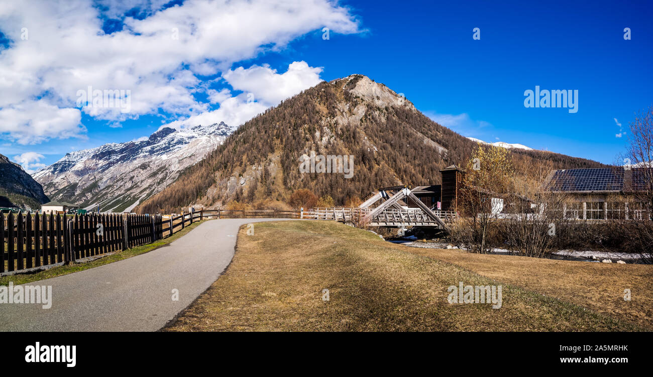 Beau panorama de la vallée de montagne avec ruisseau, arbres, sentier et pont de bois, Livigno est une petite ville et centre de ski des Alpes italiennes, Italie Banque D'Images