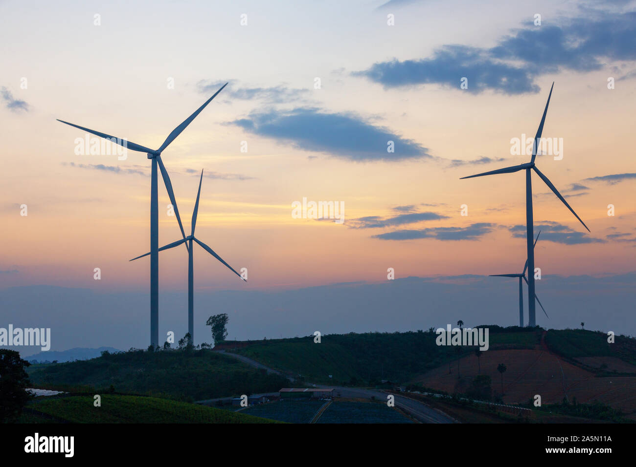 Les moulins à vent de la production végétale de l'électricité l'énergie verte silhouette sunset on the mountain Banque D'Images
