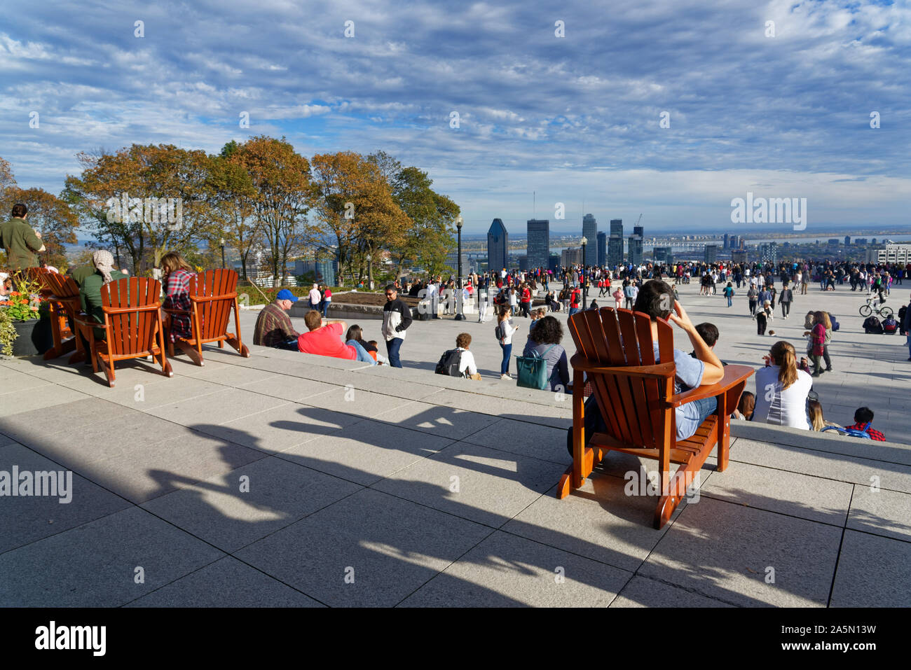 Un homme se détendre au soleil sur le belvédère Kondiaronk Montréal sur le Mont Royal, avec les gratte-ciel du centre-ville au-delà Banque D'Images