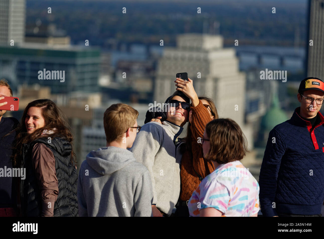 Un jeune couple en tenant vos autoportraits sur le belvédère Kondiaronk Montréal sur le Mont Royal, avec les gratte-ciel du centre-ville au-delà Banque D'Images