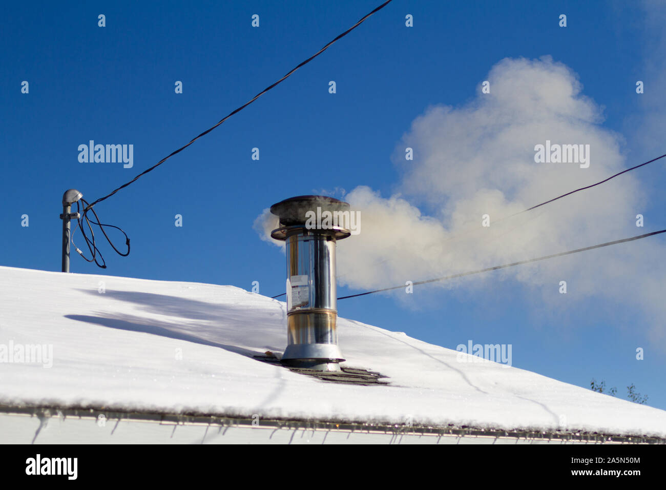 Gray la fumée sortir d'un poêle à bois cheminée. Banque D'Images