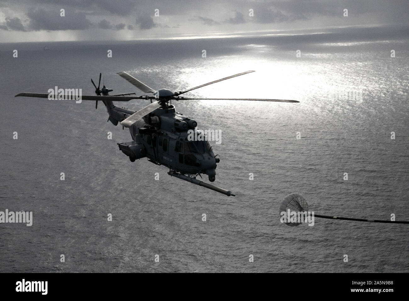 Un Eurocopter EC725 français se prépare à se connecter à un U.S. Air Force MC-130J II Commando affecté à la 67e, 352e Escadron d'Opérations spéciales Opérations spéciales, au cours d'une aile de ravitaillement en vol de l'hélicoptère (HAAR) exercer dans le cadre de l'opération de dunes sombres le 15 octobre 2019, à l'extérieur de la Base Aérienne de Cazaux, France. L'opération militaire américaine Dark Dune permet la possibilité de s'entraîner avec prêt et capable d'unités militaires françaises, tout en augmentant l'interopérabilité et de familiarisation au sein des forces d'opérations spéciales de l'OTAN. (U.S. Photo de l'armée par le Sgt. Alexis Washburn-Jasinski) Banque D'Images