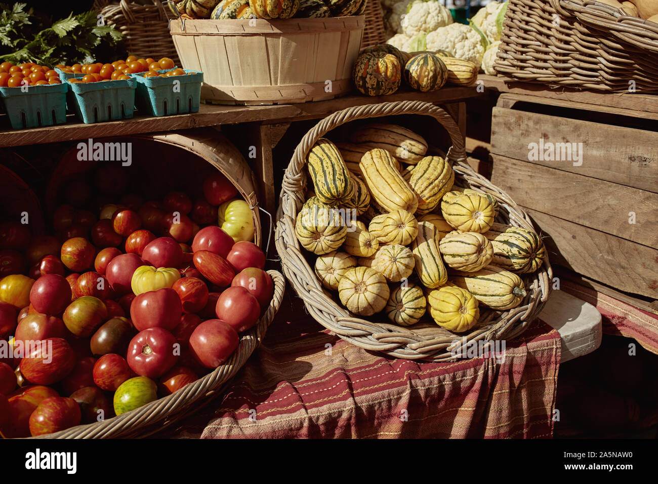 Des paniers remplis d'héritage avec tomates et courges d'hiver à vendre à un marché de producteurs à Copley Square. Cucurbita maxima et Lycopersicon esculentum Banque D'Images