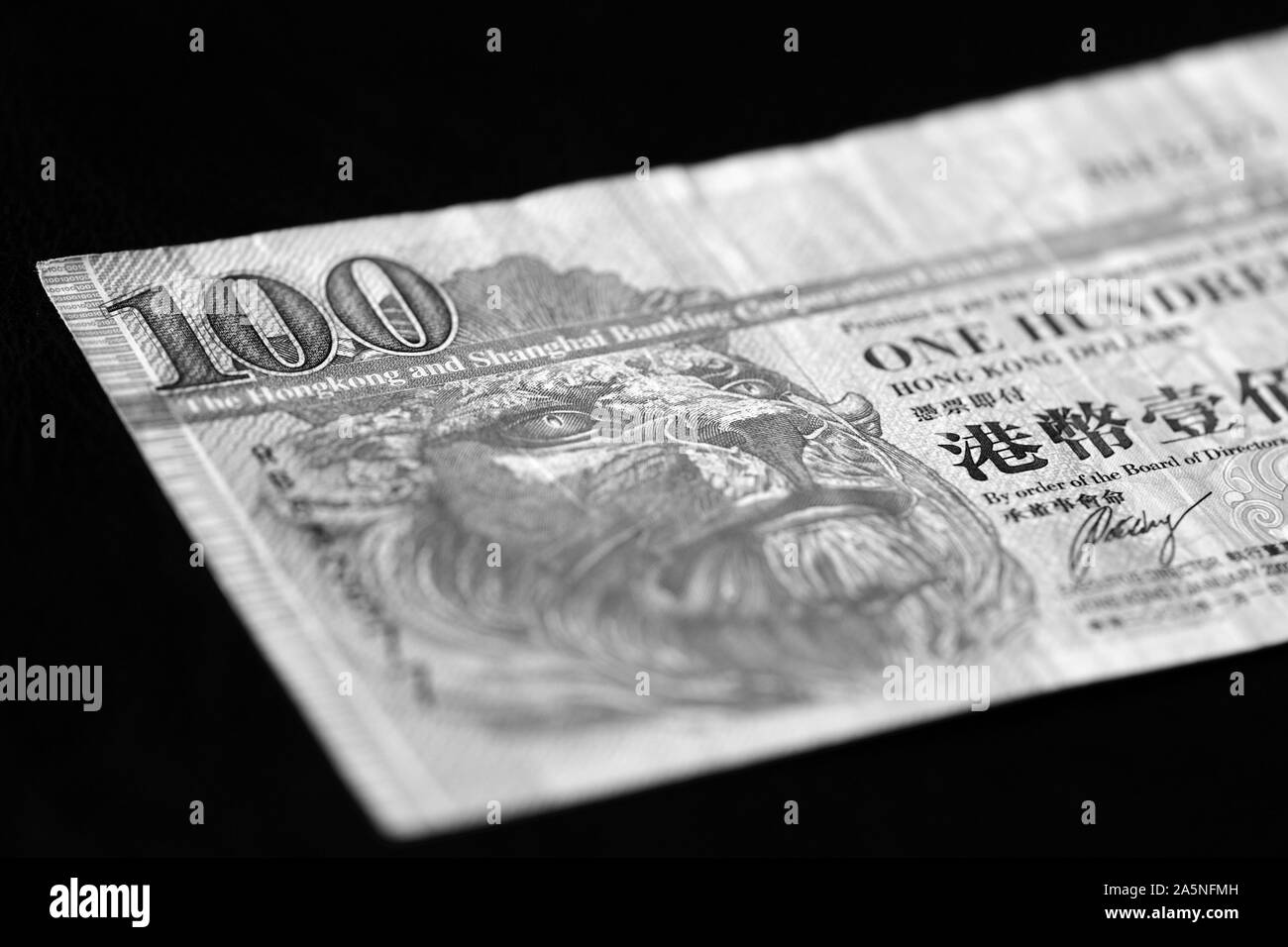 Une centaine de dollars de Hong Kong Billet sur un fond sombre de près. Le noir et blanc Banque D'Images