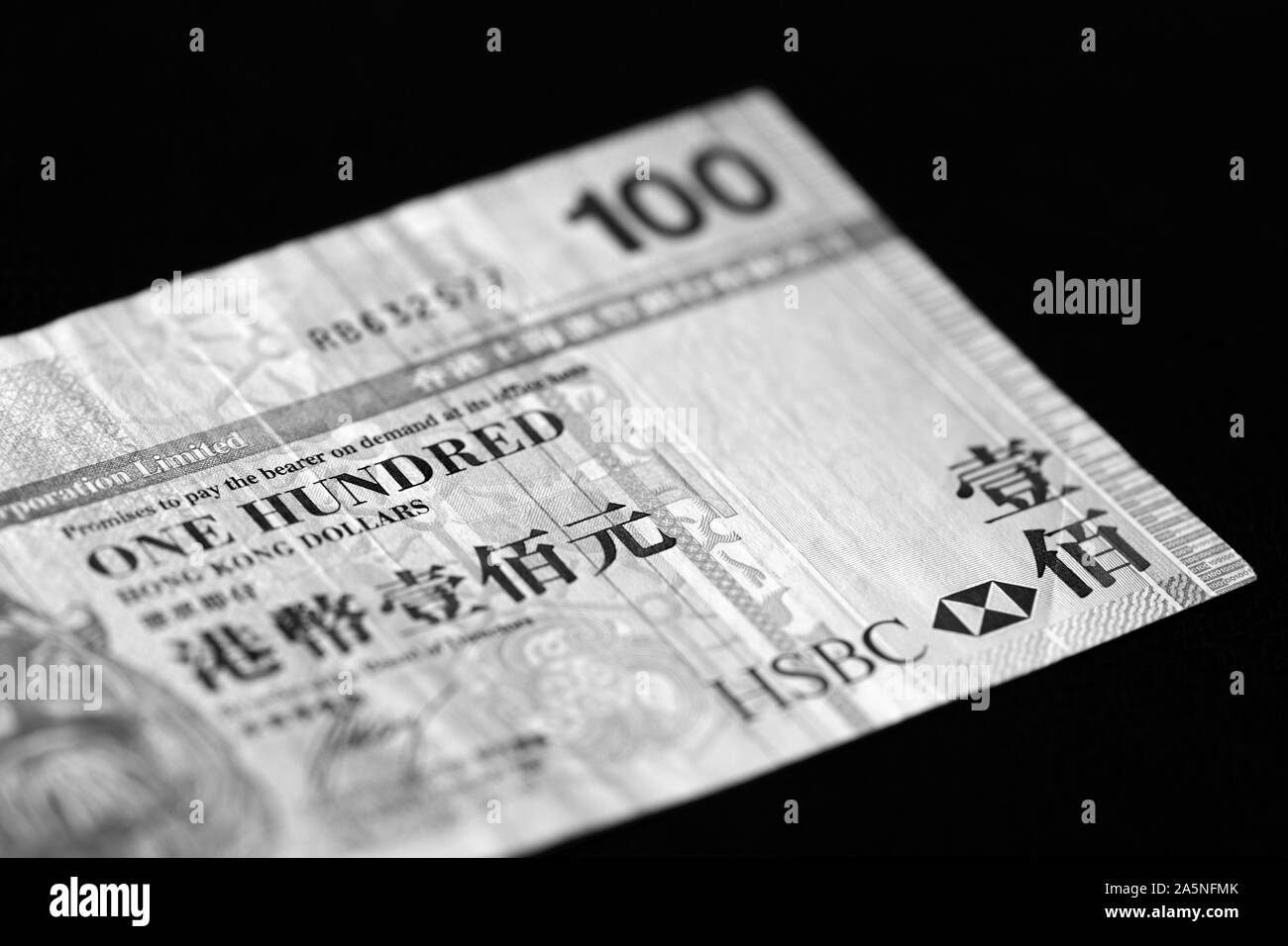 Une centaine de dollars de Hong Kong Billet sur un fond sombre de près. Le noir et blanc Banque D'Images