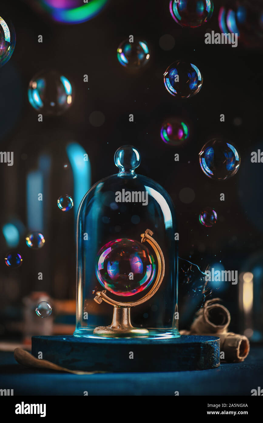 Bulle de savon dans un globe châssis sous un dôme en verre. Écologie et notion de changement climatique. Terre fragile still life with copy space Banque D'Images