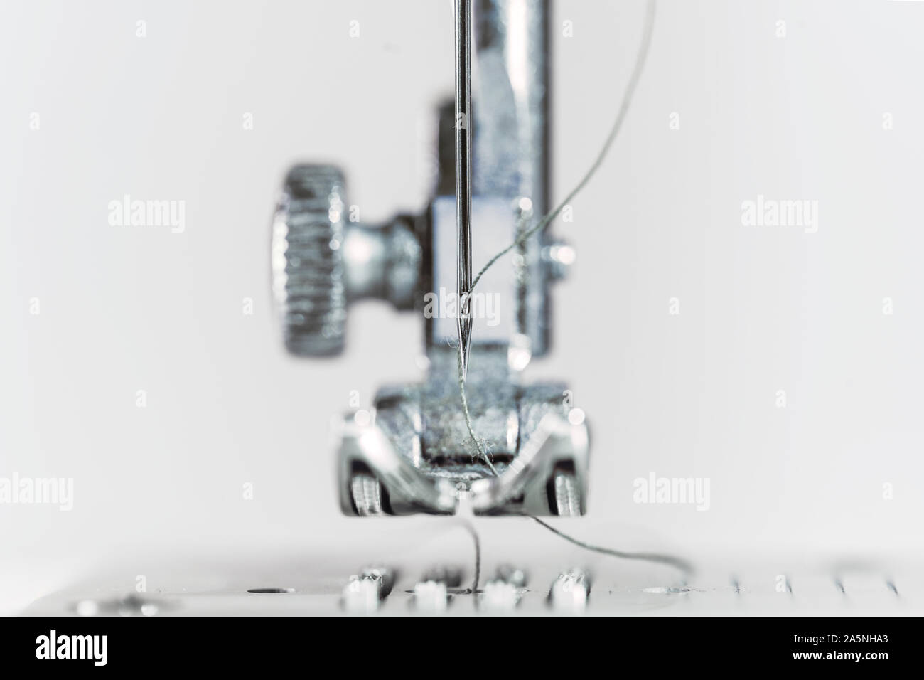 L'aiguille et le pied presseur de la machine à coudre comme un plan macro extrême, invention technique pour l'industrie du vêtement, l'arrière-plan lumineux avec copie espace, s Banque D'Images L'aiguille et le pied presseur de la machine à coudre comme un plan macro extrême, invention technique pour l'industrie du vêtement, l'arrière-plan lumineux avec copie espace, s Banque D'Images