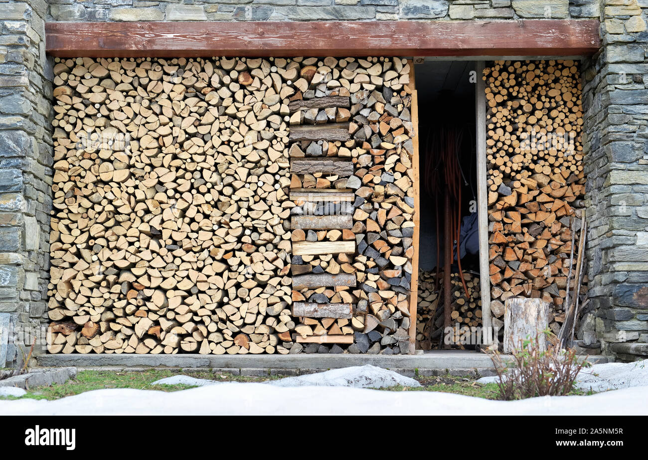 Pile de bois de chauffage a organisé la formation d'un mur extérieur à partir de la mémoire un cottage en pierre Banque D'Images