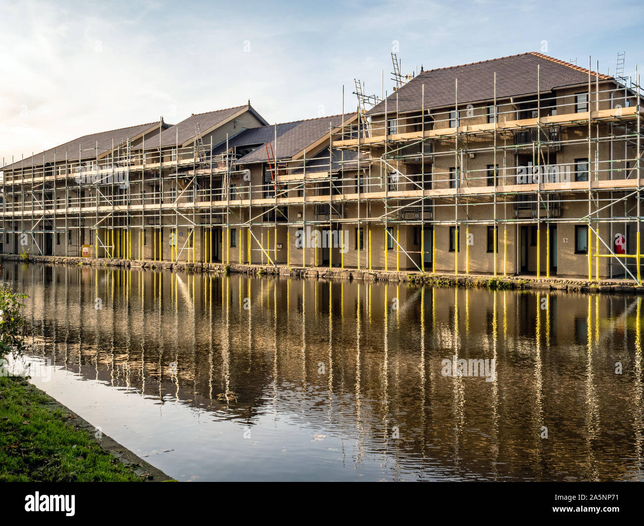 Appartements couverts d'échafaudages par Canal de Lancaster, Lancashire, England, UK. Banque D'Images