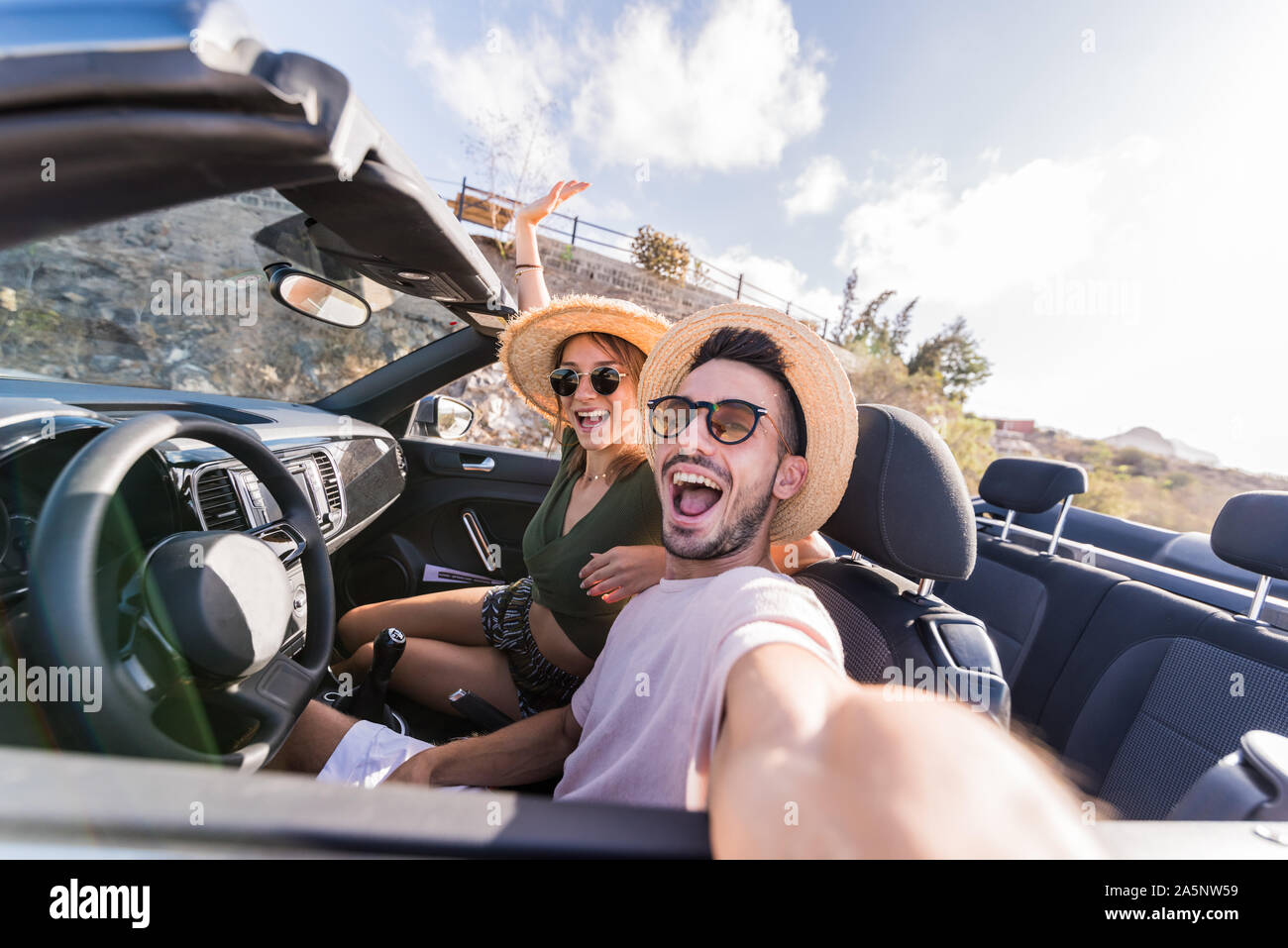 Couple heureux en amour en prenant un voyage de route quand selfies dans une voiture décapotable Banque D'Images