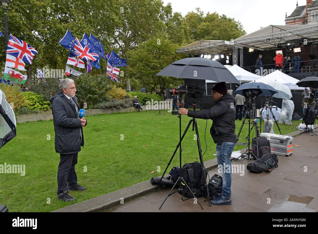 Alghad équipe de télévision arabe film un reportage au sujet d'un Brexit fond de drapeaux de l'UE & Brexit plaques sur College Green, Westminster, 21/10/19 Banque D'Images