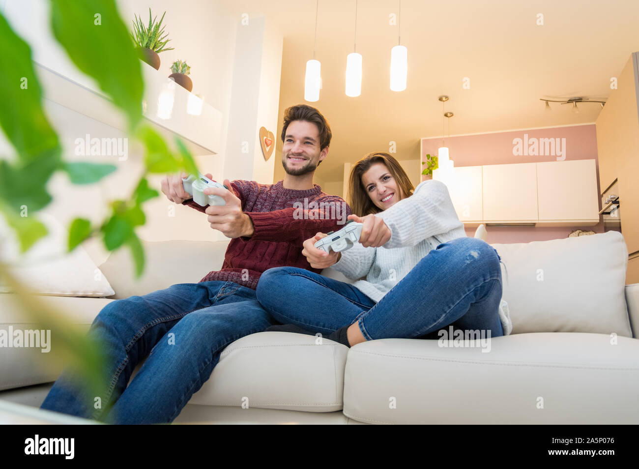 Jeune couple s'amusant les jeux vidéo à la maison. Banque D'Images