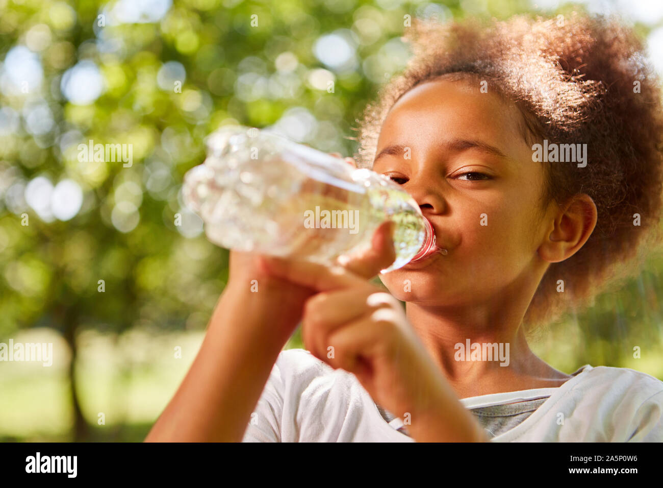 Jeune fille africaine de l'eau en bouteille de boissons une bouteille Banque D'Images