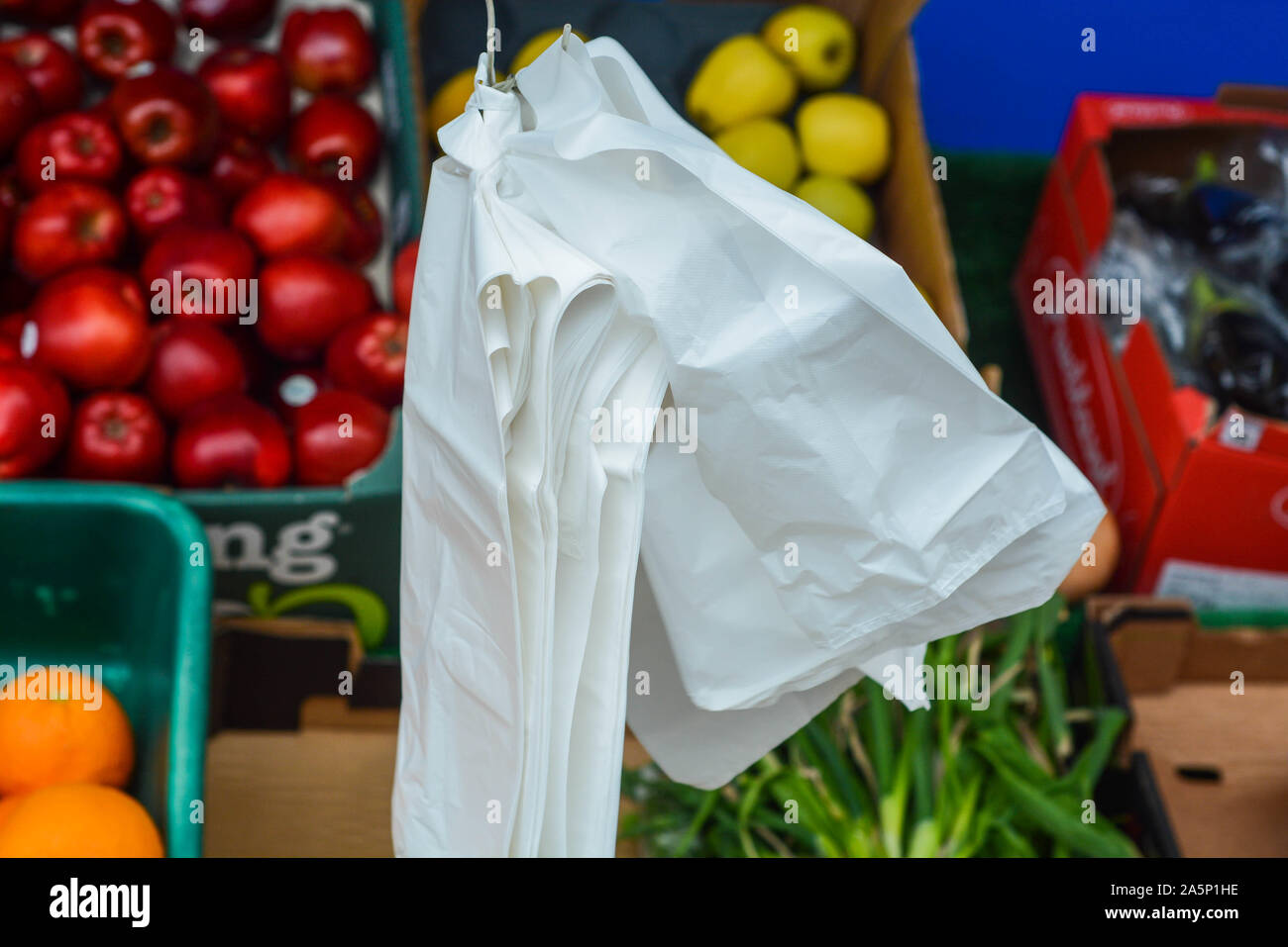 Sacs en plastique à usage unique accroché à l'extérieur de la boutique à côté des fruits et légumes Banque D'Images