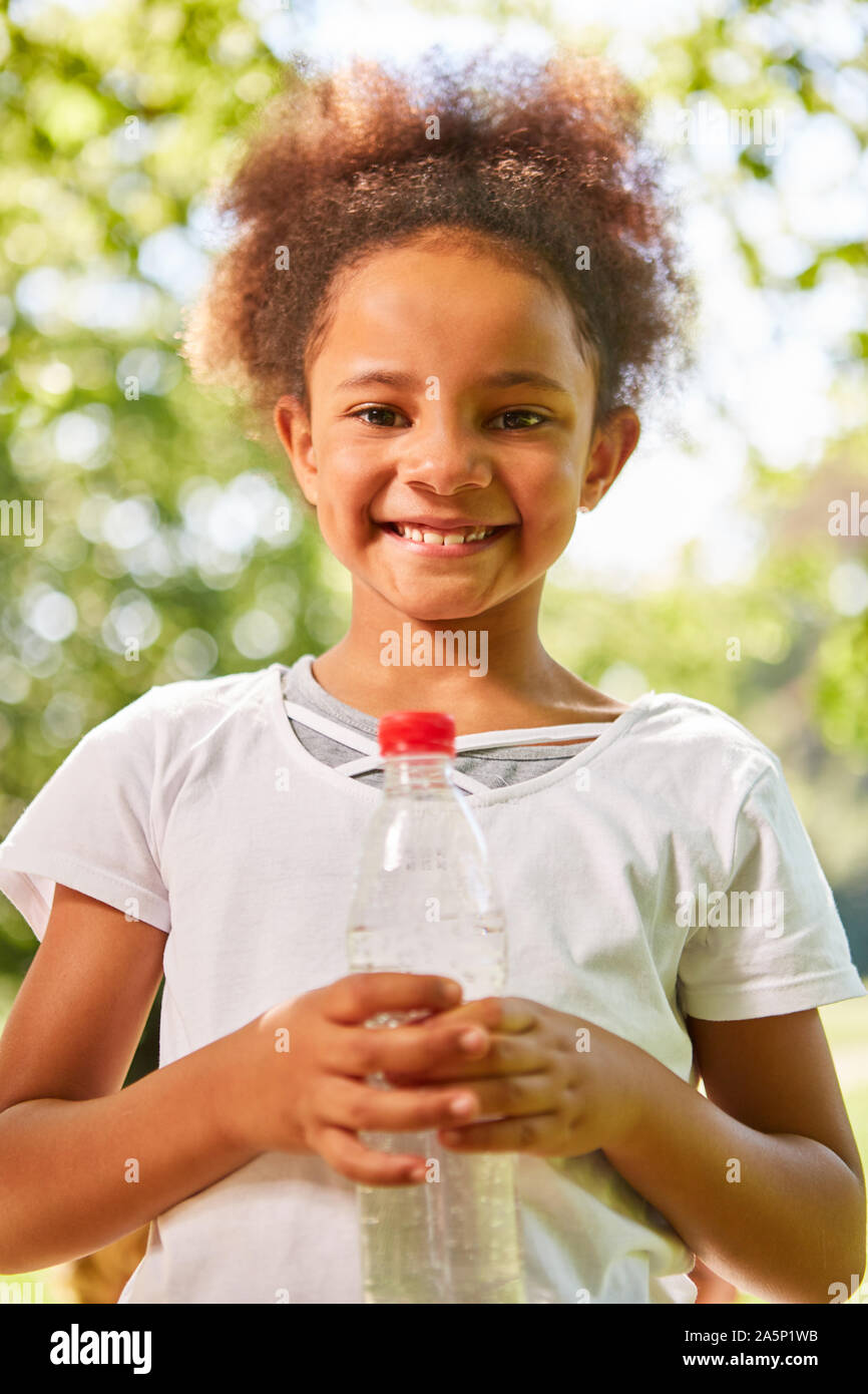 Jeune fille africaine avec une bouteille d'eau sur un tour Banque D'Images