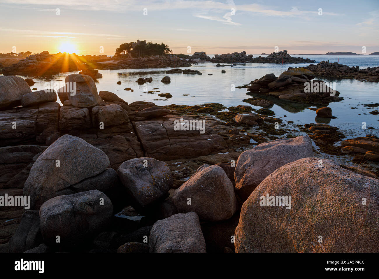 Soleil derrière l'Île de Costaérès, Ploumanac'h, la Côte de Granit Rose, Bretagne, France Banque D'Images