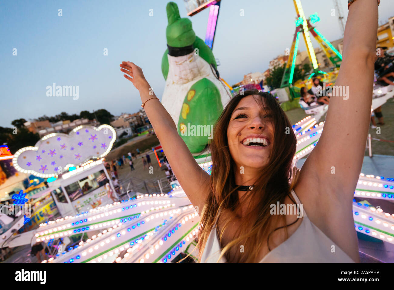 Young woman enjoying et passe un tour dans une fête foraine Banque D'Images