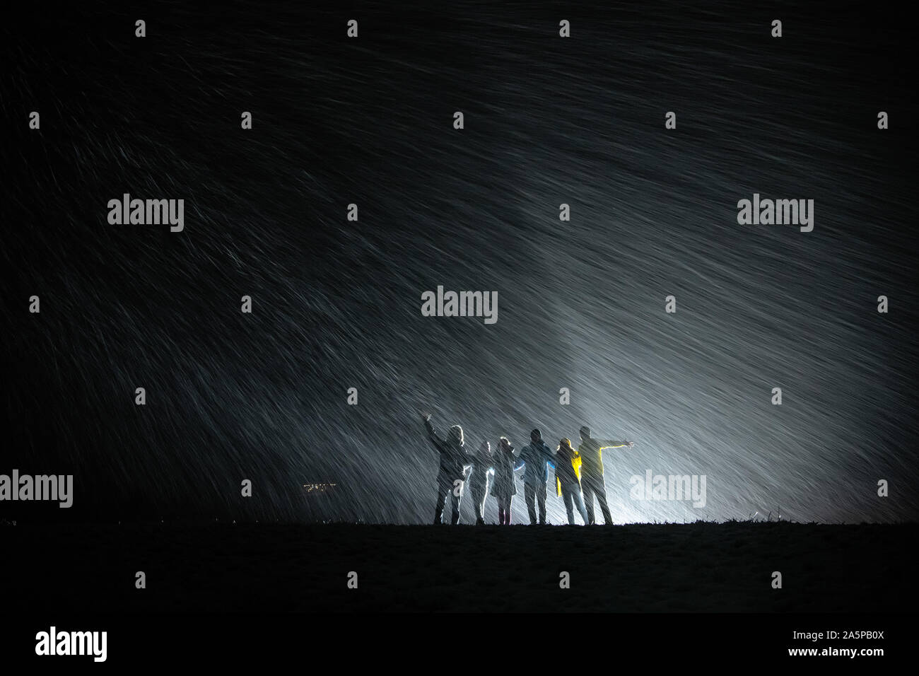 Groupe de silhouettes se tient ensemble contre Neige et lumière arrière et d'avoir du plaisir Banque D'Images Groupe de silhouettes se tient ensemble contre Neige et lumière arrière et d'avoir du plaisir Banque D'Images