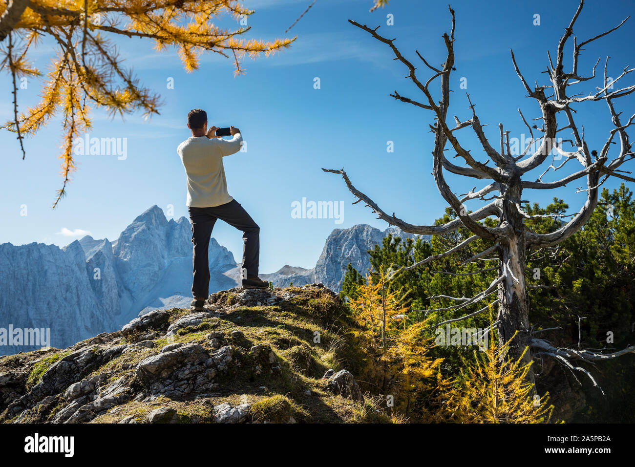 Climber prenant une photo sur le sommet de la montagne Banque D'Images